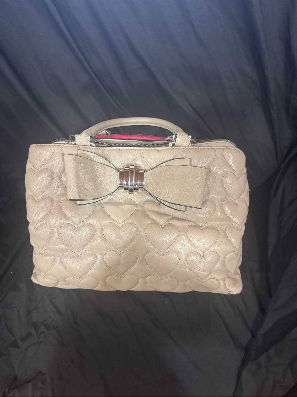 This Betsey Johnson light grey quilted heart satchel features an oversized front